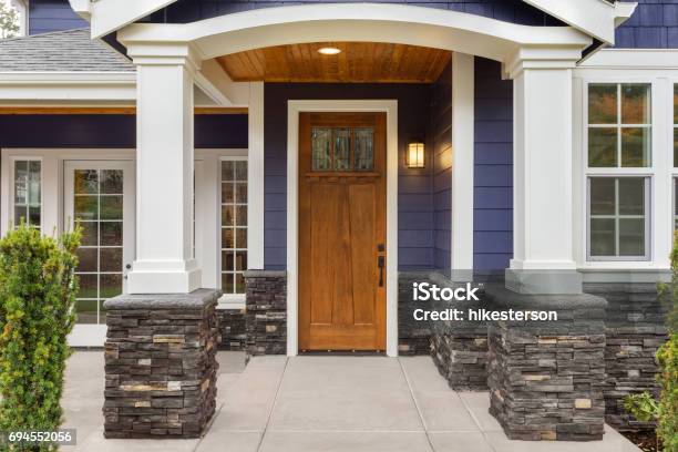 New Luxury Home Exterior Detail Patio And Front Door With Arch And Columns Stonework Graces The Bottom Of The Columns And House While White Columns And Archway Provide A Stately Welcome Stock Photo - Download Image Now