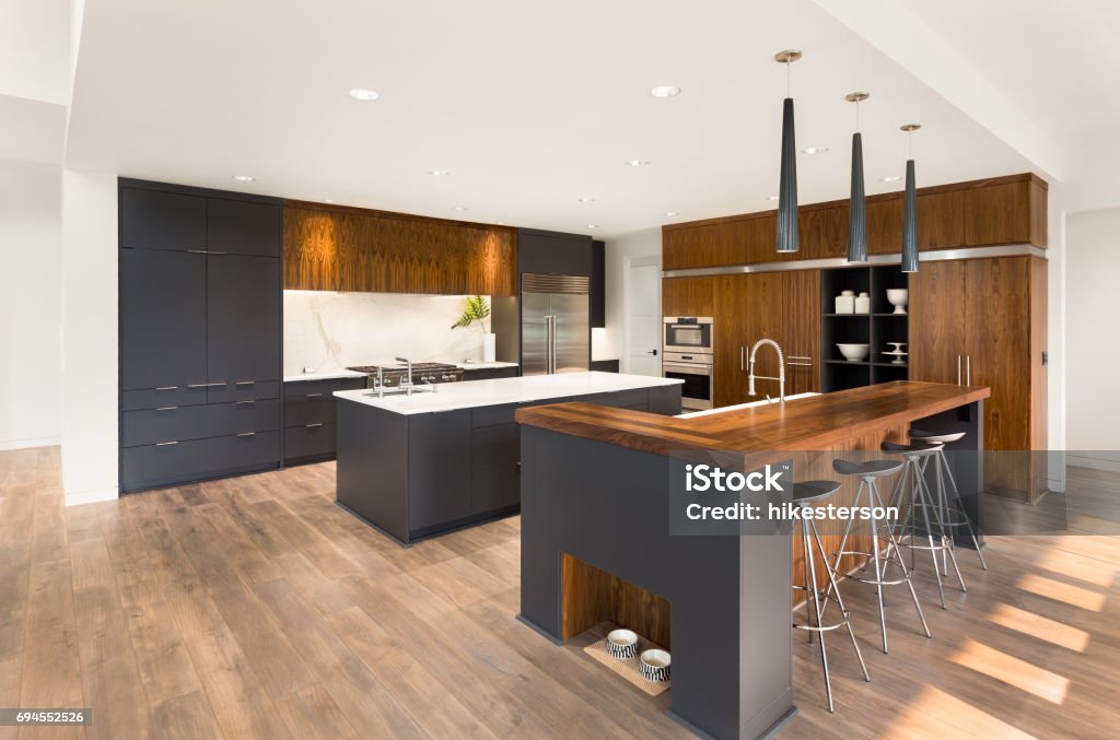 beautiful kitchen in new luxury home with two islands, two sinks, pendant lights, oven, range, and hardwood floors kitchen in newly constructed luxury home Kitchen Stock Photo