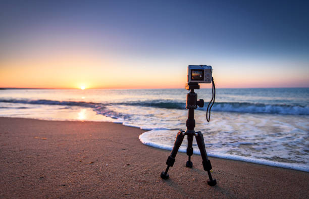 istock Camera on a tripod on the sunset background. Golden sands 694552986