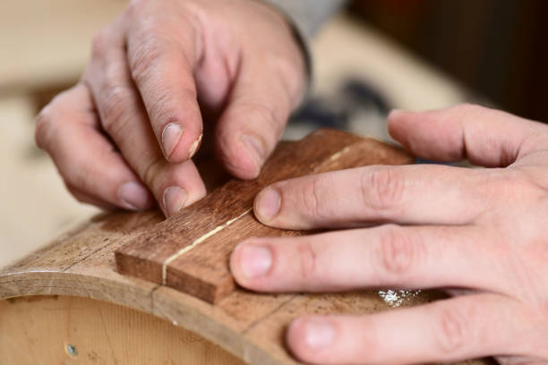 istock Carpenter glueing wooden parts for drum with bare hands 694565682