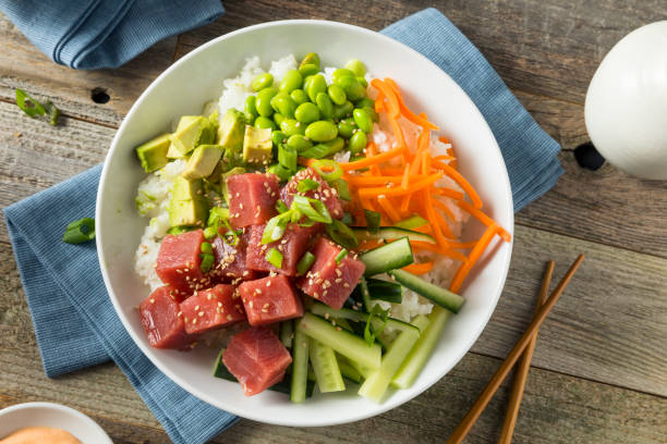 Raw Organic Ahi Tuna Poke Bowl Raw Organic Ahi Tuna Poke Bowl with Rice and Veggies fish in a bowl stock pictures, royalty-free photos & images
