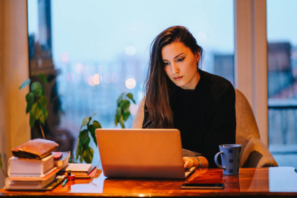 istock Young woman working late at home 694578836