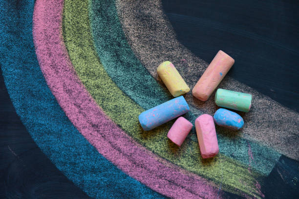 istock Pieces of school chalk on old black chalkboard closeup 694578840