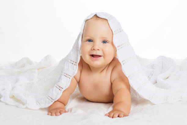 istock Cute smiling baby under towel after bath 694588124
