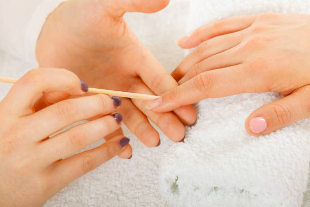 istock Beautician preparing nails before manicure, pushing back cuticles 694588404