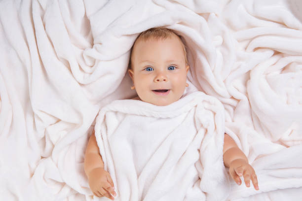 istock Cute smiling baby under towel after bath 694592282