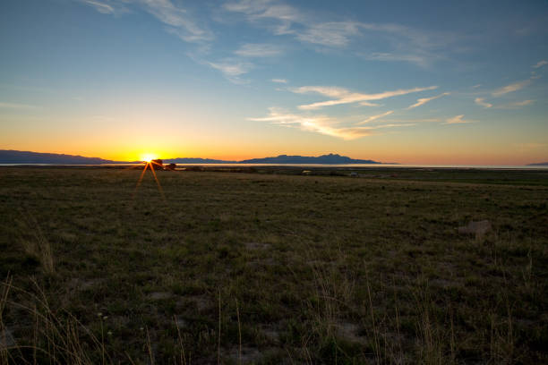 Lens flare at sunset over Adobe Rock with Stansbury Mountains and the Great Salt Lake in distance. Shot in Erda, Tooele County, Utah.