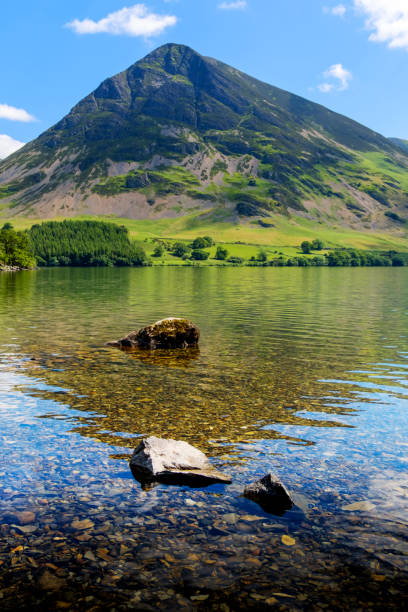 Low angle view looking across the tranquil water of Loweswater to a distant fell
