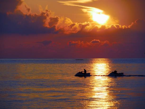 istock Silhouette of a man in a jet ski at sunset 694611026