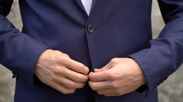 istock The man fastens buttons on his jacket close up 694616674
