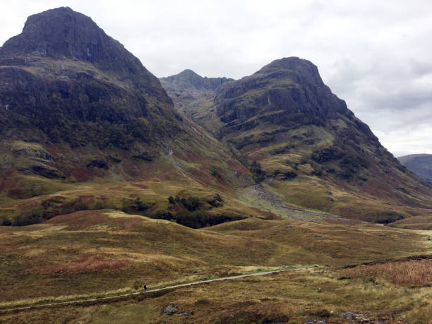 Scenery in Glencoe Scotland Tall rough peaks in the Glencoe area of Scotland. A person can be seen walking along a trail at bottom of picture. shanghai cooperation organization stock pictures, royalty-free photos & images