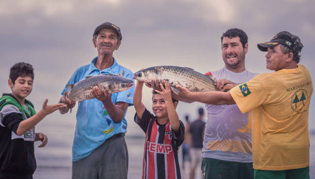 Ilha Do Mel, Paraná, Brazil - June 3, 2017: Native fishermen from Honey Island holding fish for the photo.