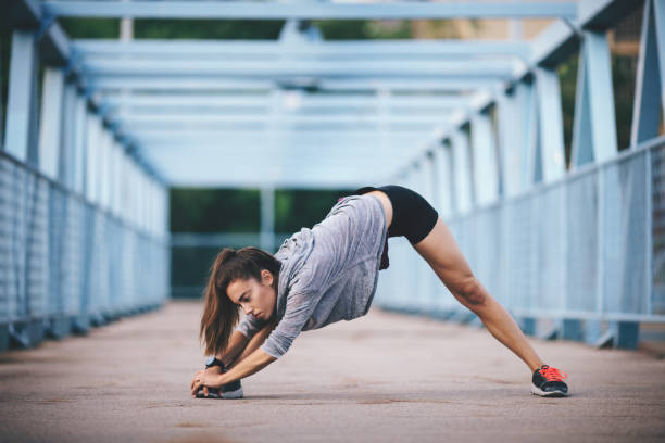 istock Young woman doing stetching exercises outdoors 694640616