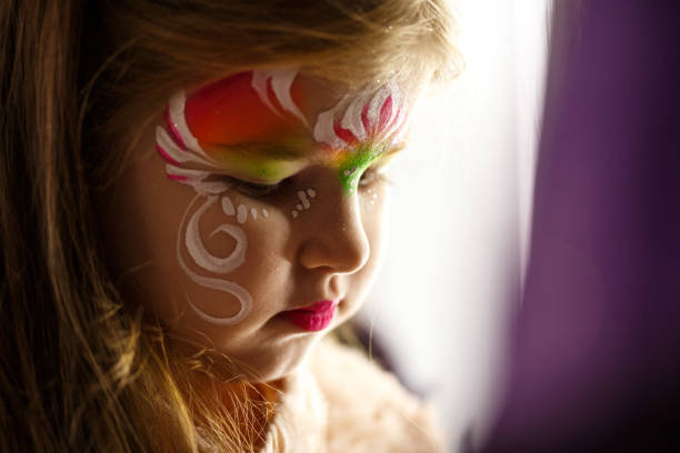 Little girl with face paint, looking away, drifting away in a fairytail land in her 