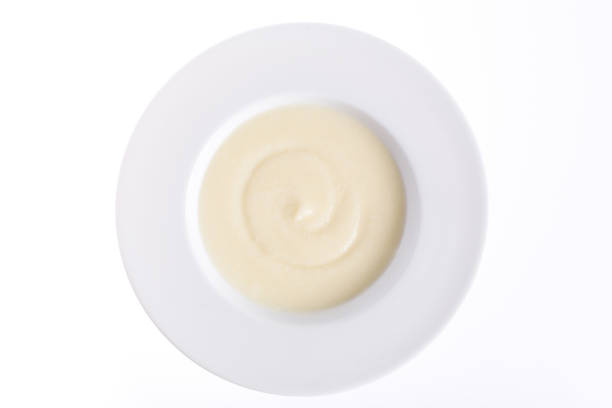 food for baby nutrition, puree of boiled vegetables: cauliflower, potatoes, yolk in a plate on a white background
