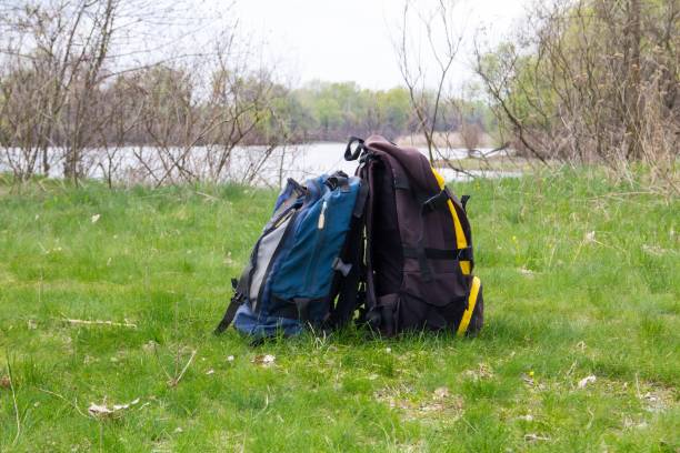 istock Two touristic backpacks on the riverbank. Hike concept 694671720