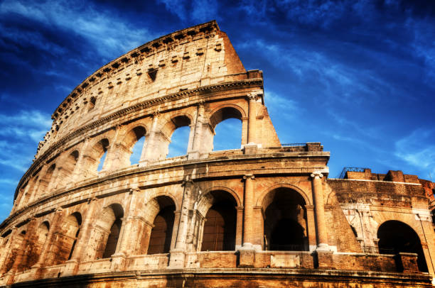 istock Colosseum in Rome, Italy. Amphitheatre over deep blue sky 694676210