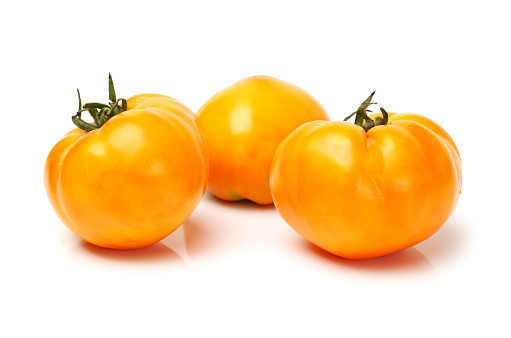 Fresh yellow tomatoes   on a white background
