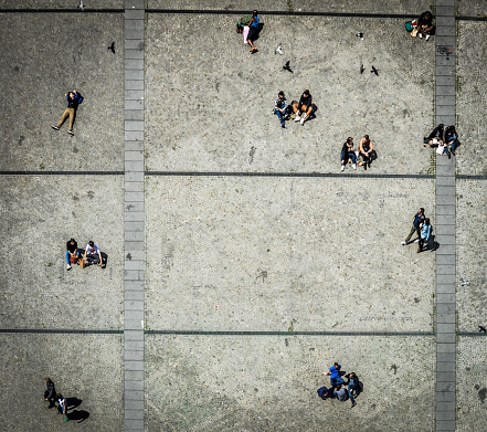 Aerial view of a crowd of people below the Pompidou Center in Paris, France. The people in this photo are enjoying a warm spring day outside.