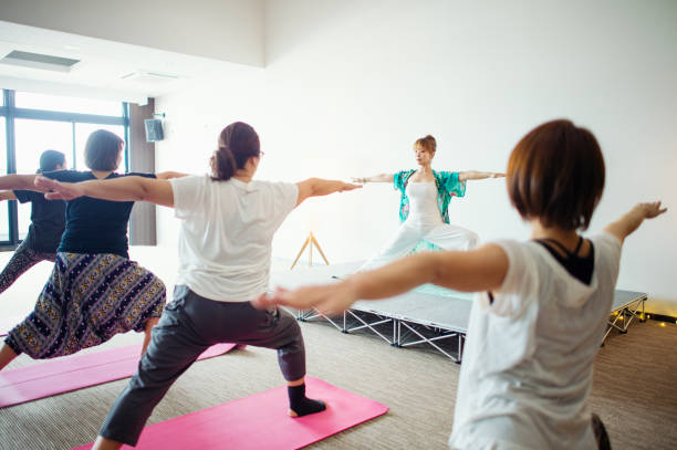 istock Women learning yoga in yoga class 694679426