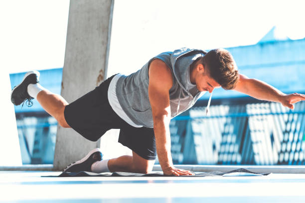 istock Male working on his core muscles outdoors 694680092