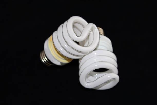A closeup of an old dusty lightbulb in the dark. A soft yellow glow.