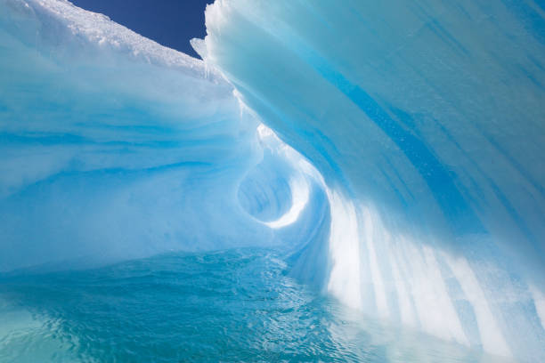 istock Amazing Wave Shaped Iceberg with perfect blue tunnel 694691804