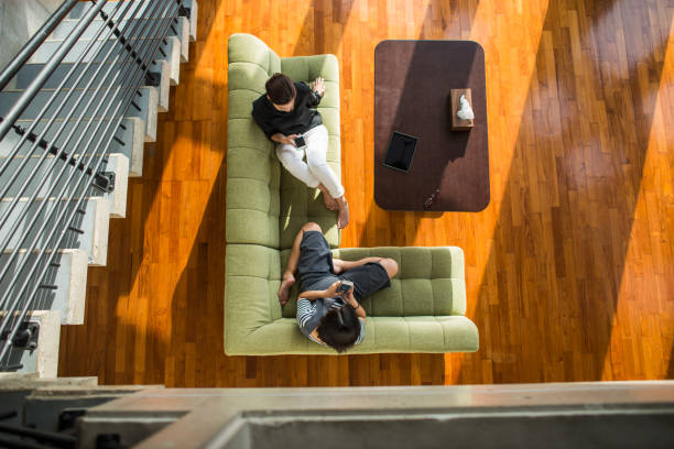istock Two women relaxing and sitting on sofa in the room 694698120