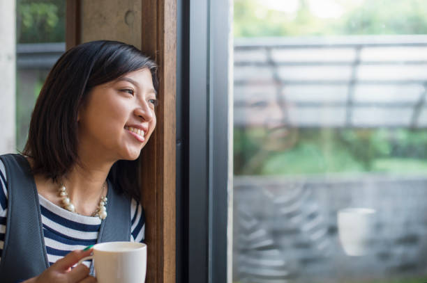 istock Young woman looking out the window 694698182
