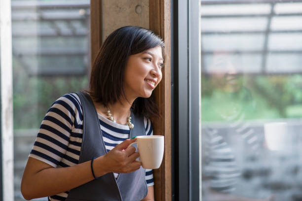 istock Young woman looking out the window 694698186