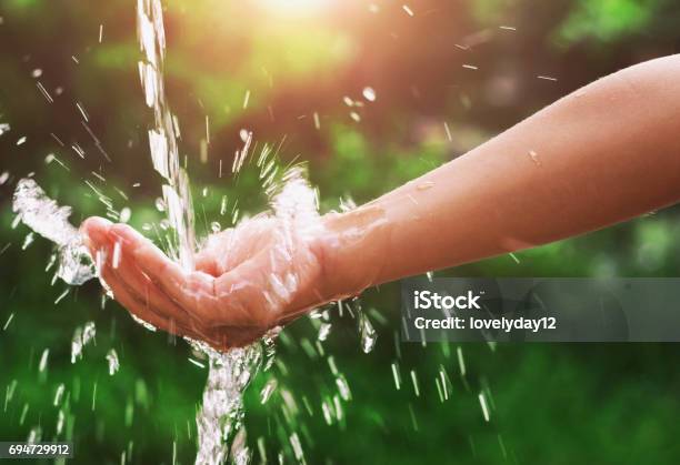 Water Pouring Splash In Hand And Nature Background With Sunshine Stock Photo - Download Image Now