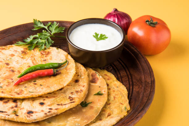 istock Traditional Indian bread - Aloo paratha or aalu parotha, potato stuffed bread. served with tomato ketchup or sauce and curd 694732072