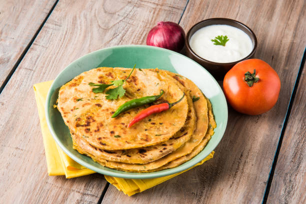 istock Traditional Indian bread - Aloo paratha or aalu parotha, potato stuffed bread. served with tomato ketchup or sauce and curd 694735748