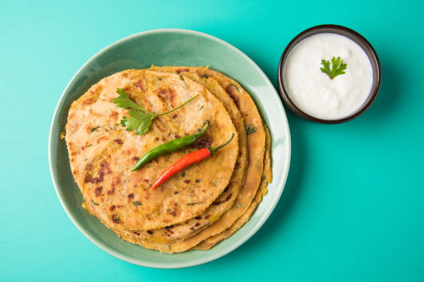 Traditional Indian bread - Aloo paratha or aalu parotha, potato stuffed bread. served with tomato ketchup or sauce and curd Traditional Indian bread - Aloo paratha or aalu parotha, potato stuffed bread. served with tomato ketchup or sauce and curd Paratha stock pictures, royalty-free photos & images