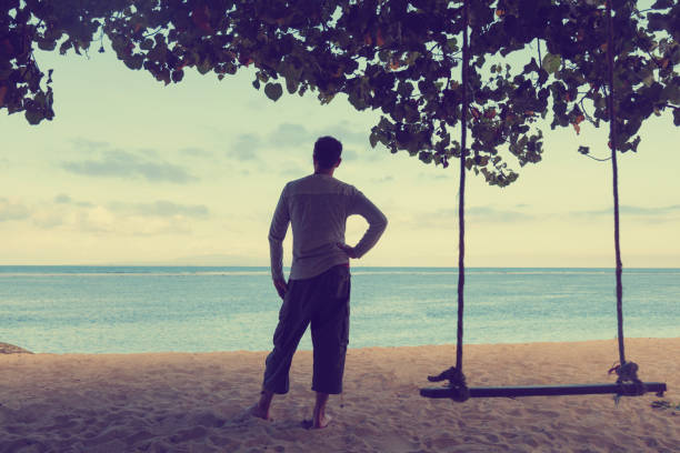 istock Young man enjoying the view on the tropical beach. 694740112