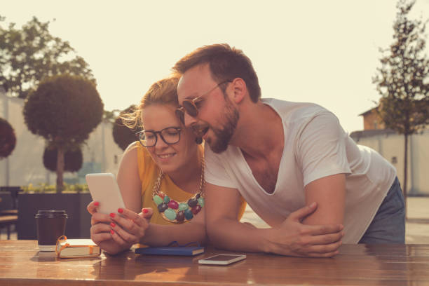 istock Couple using cellphone outdoors. 694742438