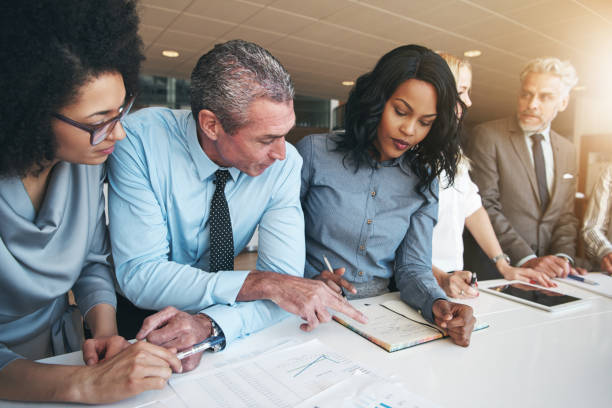istock Multiracial workers discussing papers sitting in office 694746678