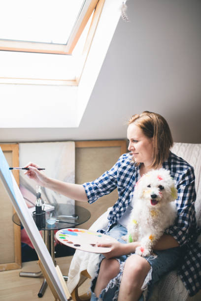 istock Getting creative.woman painting with his dog in his studio 694753330