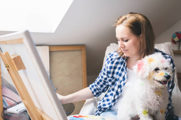 istock Getting creative.woman painting with his dog in his studio 694754066
