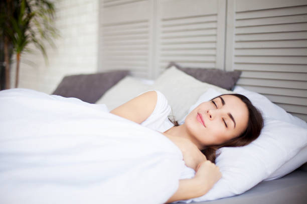 istock woman lying or sleeping in bedroom in sunny morning 694760414