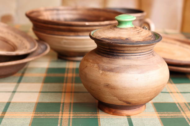 istock Ceramic handmade pottery jug with plates on tablecloth in green cage 694763968