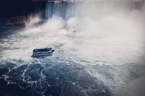 istock boat with tourists in Niagara Falls 694764004