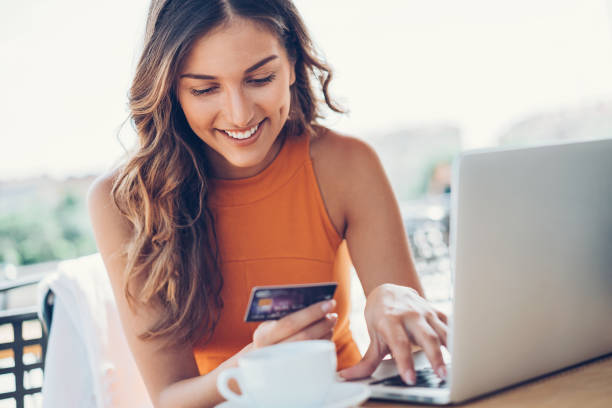 Smiling woman with credit card and laptop Beautiful young woman with credit card and laptop in cafe young women shopping stock pictures, royalty-free photos & images