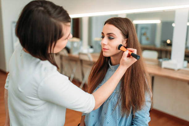 istock Female make up artist applying make-up with brush 694777654