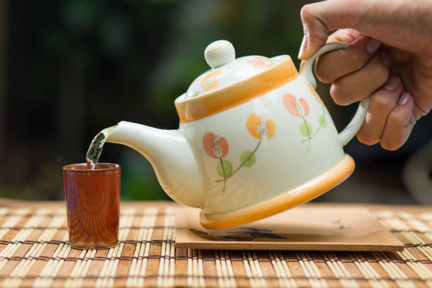 istock Pouring tea with teapot on wooden table , breaking time 694795674