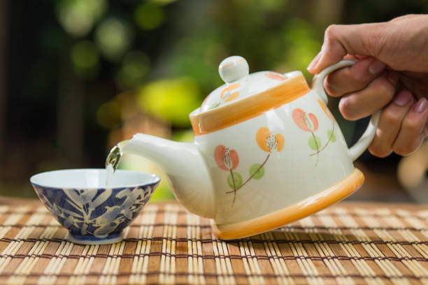 istock Pouring tea with teapot on wooden table , breaking time 694795894