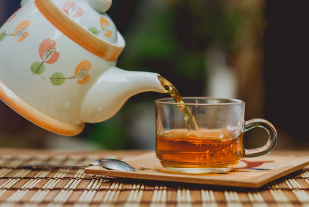 istock Pouring tea with teapot on wooden table , breaking time 694798244