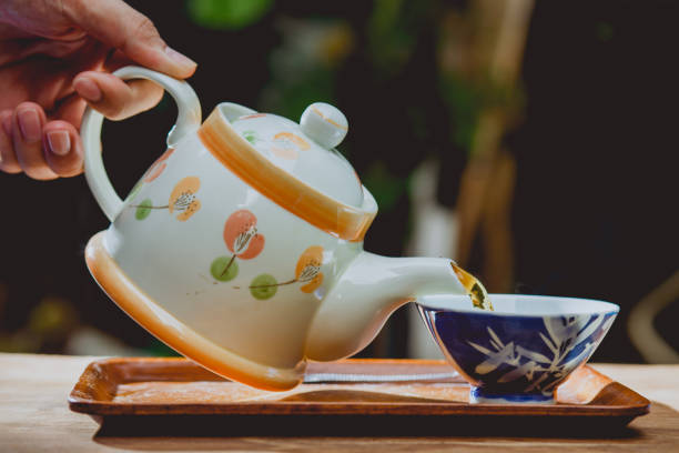 istock Pouring tea with teapot on wooden table , breaking time 694798430