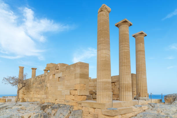 istock Ancient Greek acropolis. Front view of columns and walls. near the tree grows. 694806120