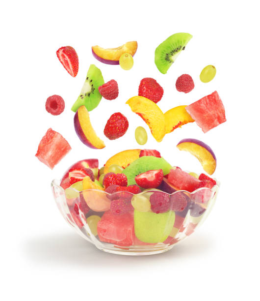 istock Fruit salad fall into glass bowl isolated on white 694827992